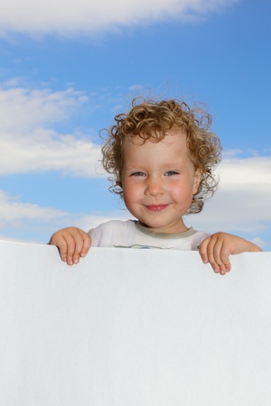 Curly girl with empty blank, against the skyの写真素材