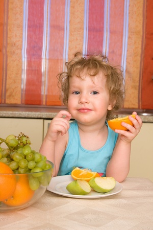 Beautiful girl eats fruit at homeの写真素材