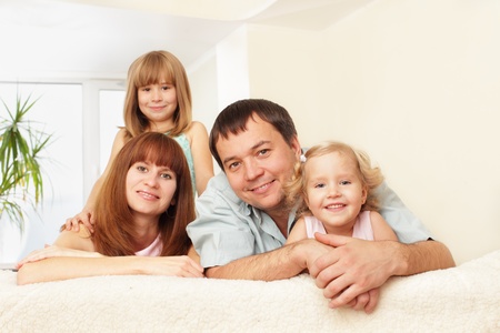 Happy family with two children on sofaの写真素材