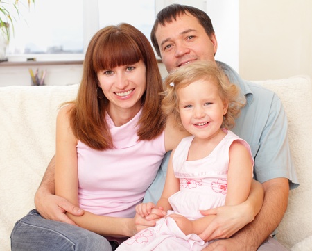 Happy family with daughter at homeの写真素材