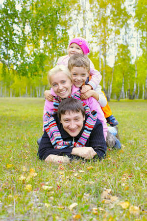 Happy family with two children in autumn parkの写真素材