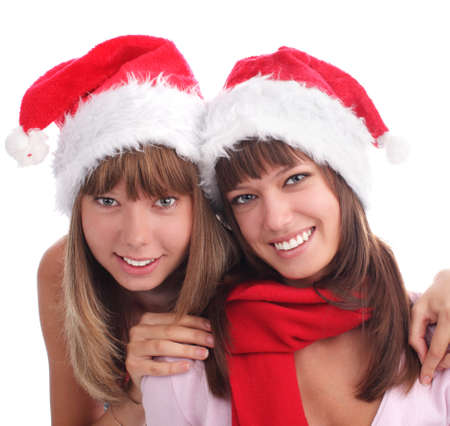 Two happy women in Christmas hats isolated on whiteの写真素材