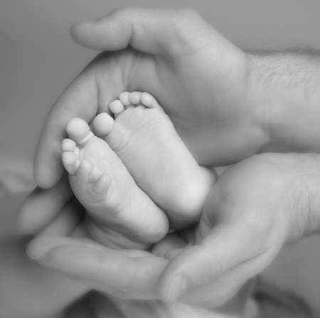 Baby's feet in daddy's handsの写真素材
