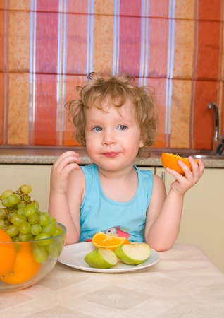 beautiful girl eats fruit at homeの写真素材
