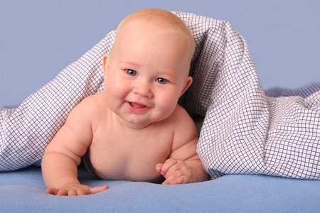 Beautiful happiness baby under a blanketの写真素材
