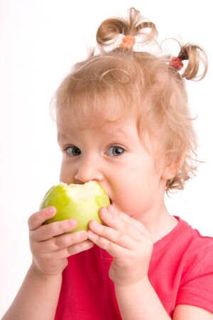 Girl eats an apple on white backgroundの写真素材