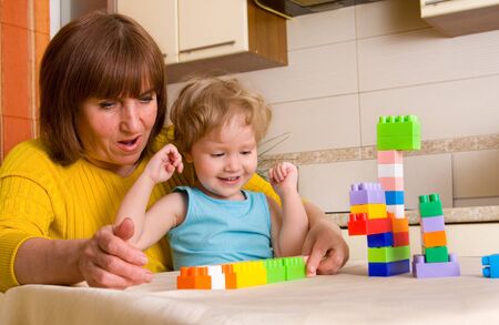 grandchild with grandmother plays cubes at homeの写真素材