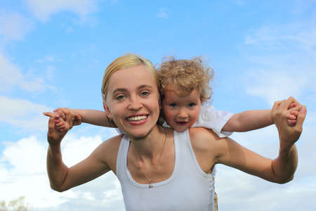 Happiness mother and daughter against the skyの写真素材