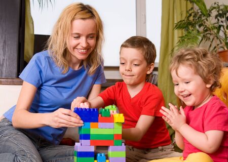 Mum with two children plays cubes の写真素材