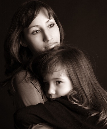 Sad mother and daughter on blackの写真素材