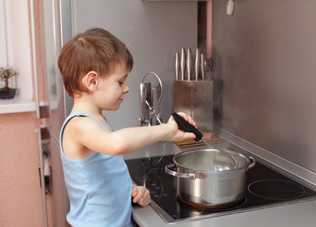 Little boy cooking porridge in kitchenの写真素材