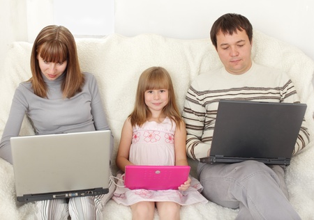 Happy family with laptop at roomの写真素材