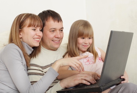 Happy family with laptop at roomの写真素材