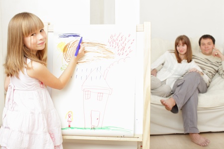 Smiling girl drawing the houseの写真素材