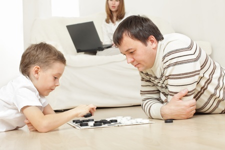 Father with the son playing draughts at homeの写真素材