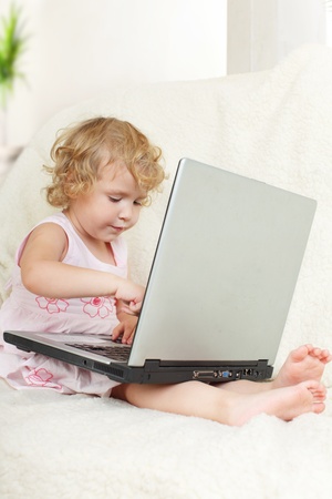 Little girl with laptop at homeの写真素材