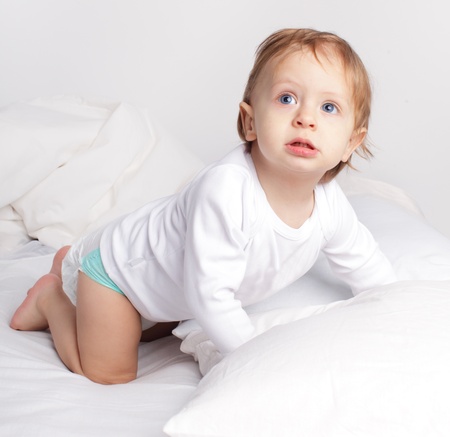 Baby laying on a bedの写真素材