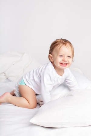 Baby laying on a bedの写真素材