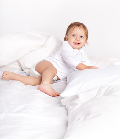 Baby laying on a bedの写真素材