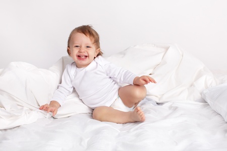 Baby laying on a bedの写真素材
