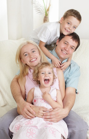 Happy family with two children on sofaの写真素材
