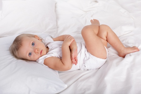 Beautiful baby in bedの写真素材