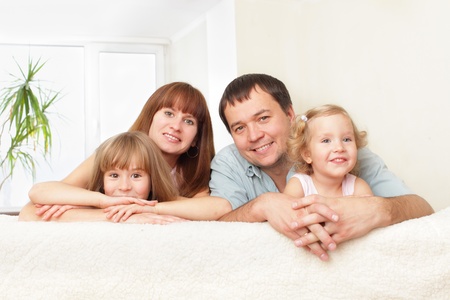 Happy family with two children on sofaの写真素材