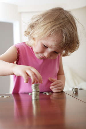Little girl putting coinsの写真素材