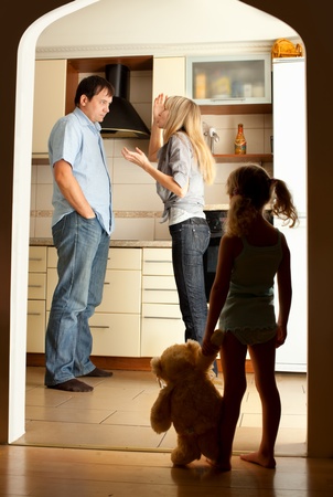 Child looks at the swearing parentsの写真素材