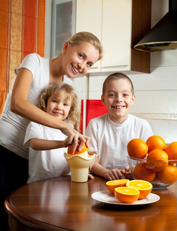 Happy mother with children squeezed orange juiceの写真素材