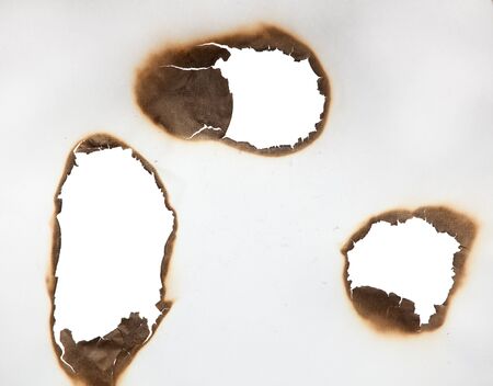 Scorched frame on paper. Burnt holeの写真素材