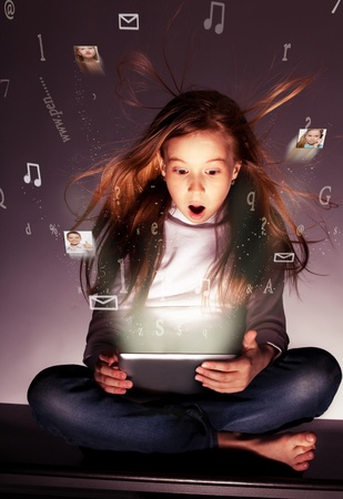 Surprised girl with tablets in hand. Flow of information, letters, photos departing from the tablet Surprised girl with tablets in hand. Flow of information, letters, photos departing from the tablet