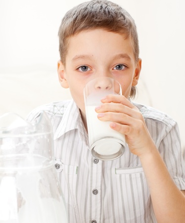 Child with glass pitcher milk. Boy drinking milk for breakfastの写真素材