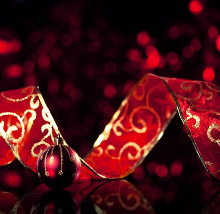 Gold christmas sphere with ribbon on black background. Christmas decorationの写真素材