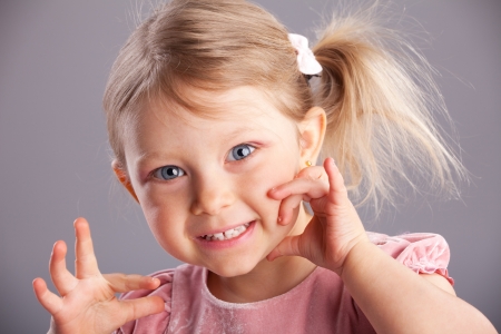 Little happy girl on gray backgroundの写真素材