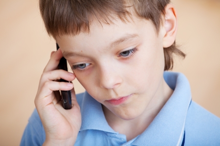 Child, talking on the phone. Sad boy talking on mobile phoneの写真素材