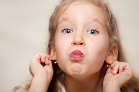 Grimacing child. Hamming little girl.の写真素材