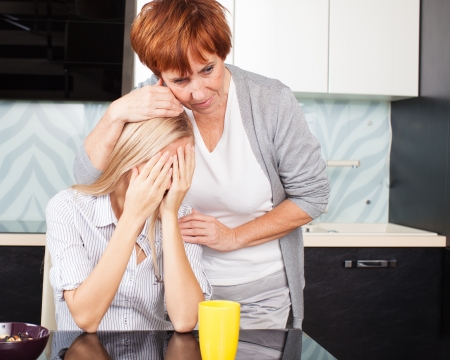Mother soothes sad daughter. Mature woman calm young womanの写真素材