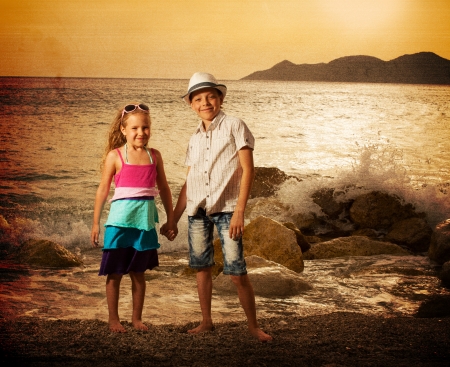 Children on the sea at sunset. Kids vacations.の写真素材