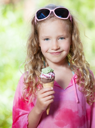Happy little girl with ice cream outdoorsの写真素材