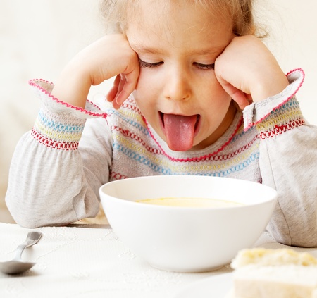 Child looks with disgust for food. の写真素材