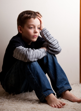 Sad boy. Depressed teenager at home. Problems at familyの写真素材
