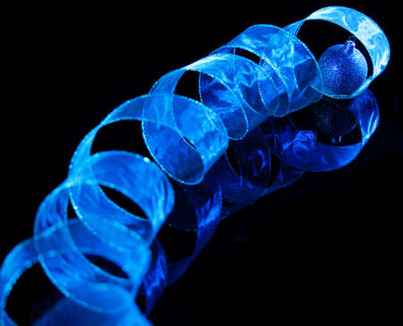 Blue christmas sphere with ribbon on black background. Christmas decorationの写真素材