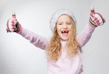 Child in christmas hat on white background. Happy little girlの写真素材