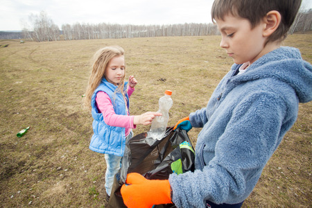 Children cleaning scavenge. Children collect garbage bag in the woodsの写真素材
