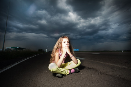 Sad girl near road. Child outdoorsの写真素材