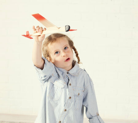 Child playing with toy. Girl with planeの写真素材