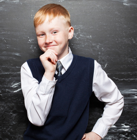Boy near blackboard. Thinking Child at school. Student at classroomの写真素材