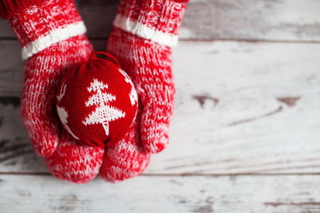 Mitten with christmas ball on wood floor. Winter decorationの写真素材