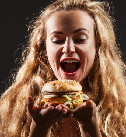 Female with hamburger. Woman eating unhealthy foodの写真素材